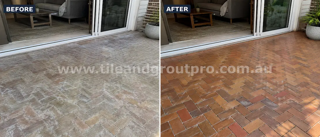 Before tile renewal, herringbone-pattern clay brick pavers in an outdoor entertaining area exhibited efflorescence, surface haze, weather staining, and dull faded colour near sliding doors.