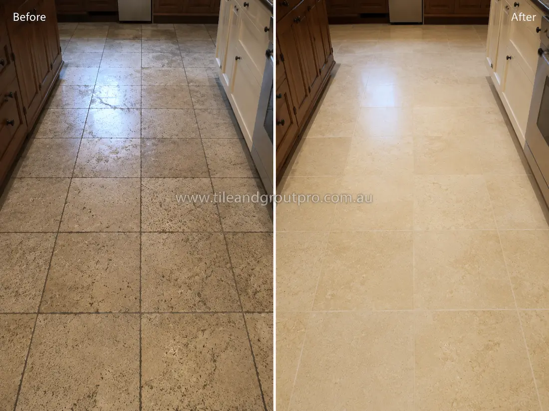 Before tile renewal, the travertine kitchen floor tiles appeared worn with dirty grout joints, faded colouring, and surface buildup in a home kitchen.