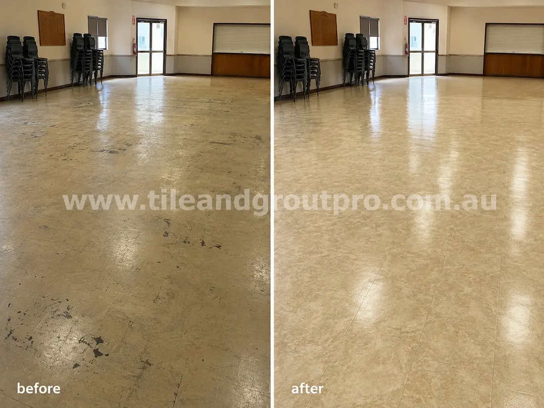 Community hall with worn beige linoleum floors before sealer stripping, showing black scuff marks, scratches, dull finish, and uneven sealer wear across the large open space.