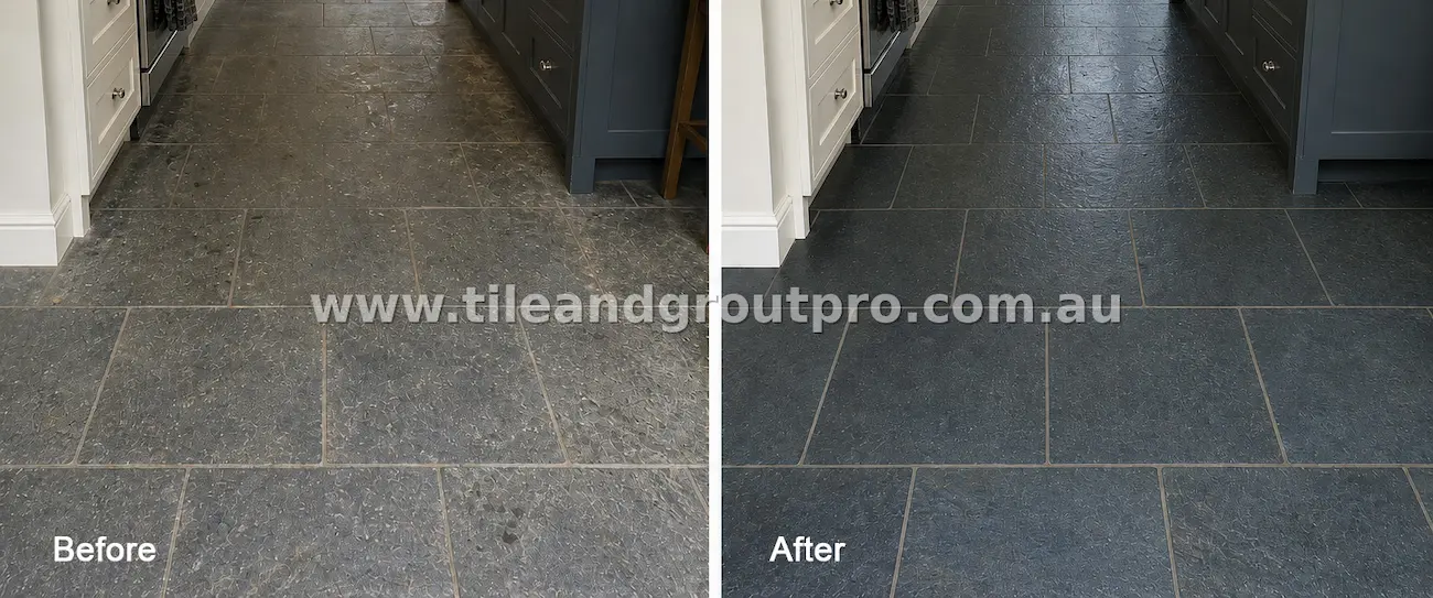 Close-up of bluestone natural stone kitchen floor tiles with embedded grime, surface dullness, and discolored grout before professional tile and grout cleaning