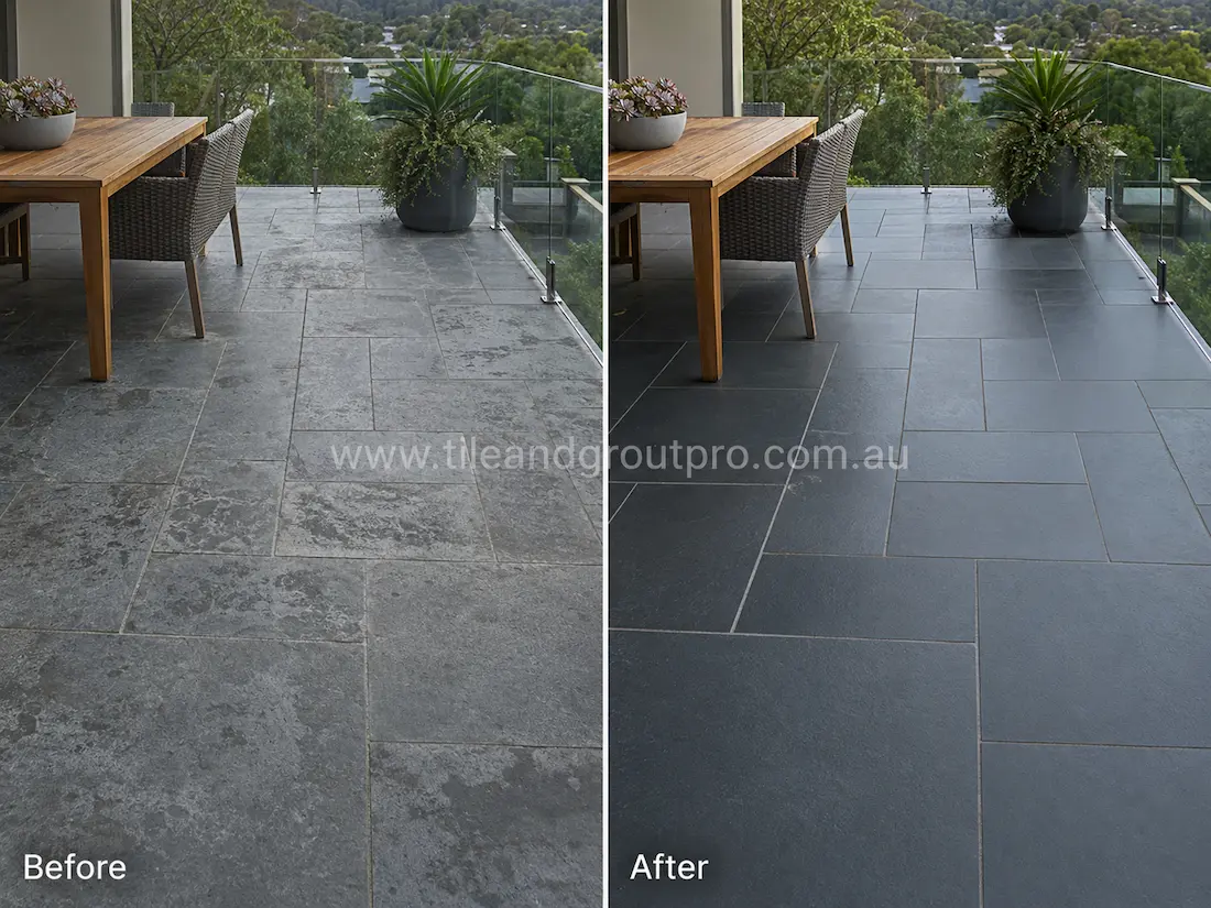 Before tile renewal, outdoor bluestone patio tiles on a balcony dining area displayed weathering, cloudy marks, and uneven surface finish around the seating and planter space.