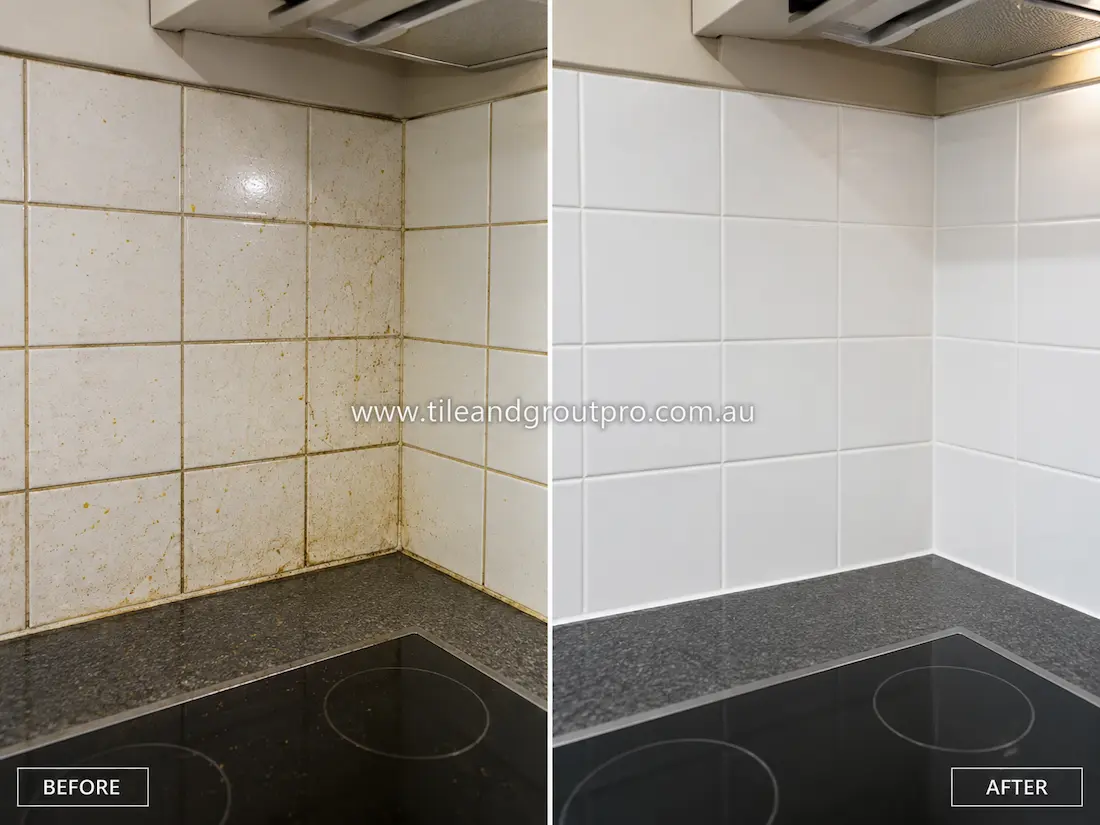 Before tile renewal, a kitchen splashback with white ceramic wall tiles behind the cooktop showed grease splatters, cooking residue, stained grout lines, and grime buildup around corners and beneath the rangehood.