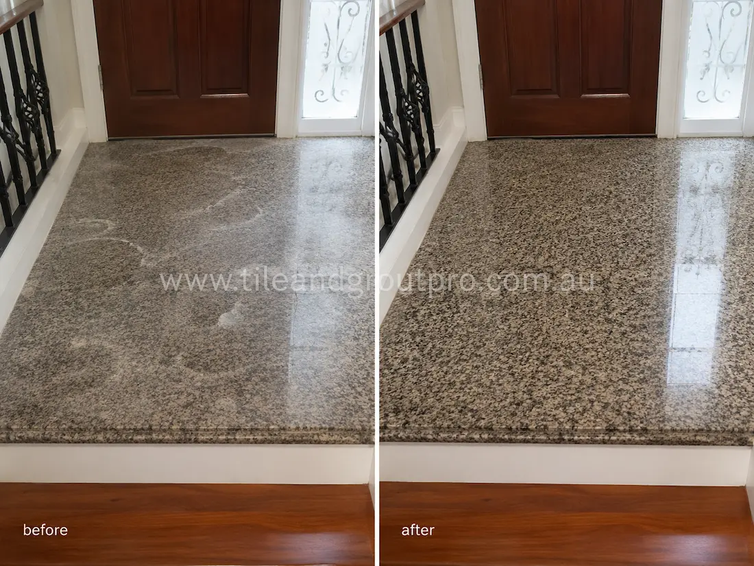 Before tile renewal, the polished granite entry floor near the front door displayed foot traffic wear, surface haze, and loss of reflective finish.