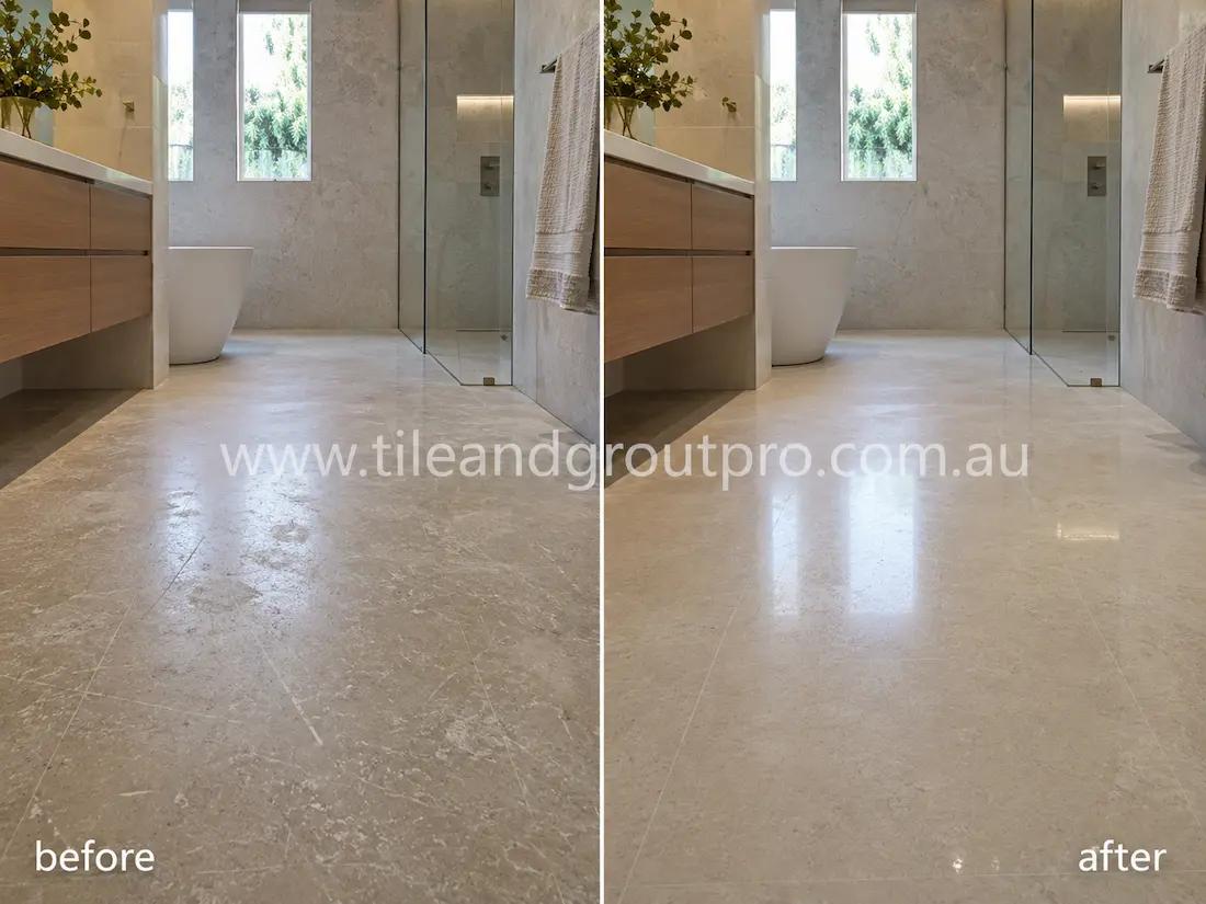 Modern bathroom limestone floor tiles before grinding, displaying etched patches, dull surface finish, and minor scratches near the shower and vanity area.
