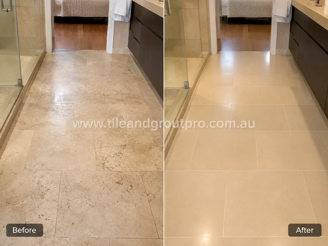 Beige limestone floor tiles in a modern bathroom with visible etching, wear patterns, and a faded finish before tile resurfacing and stone restoration.