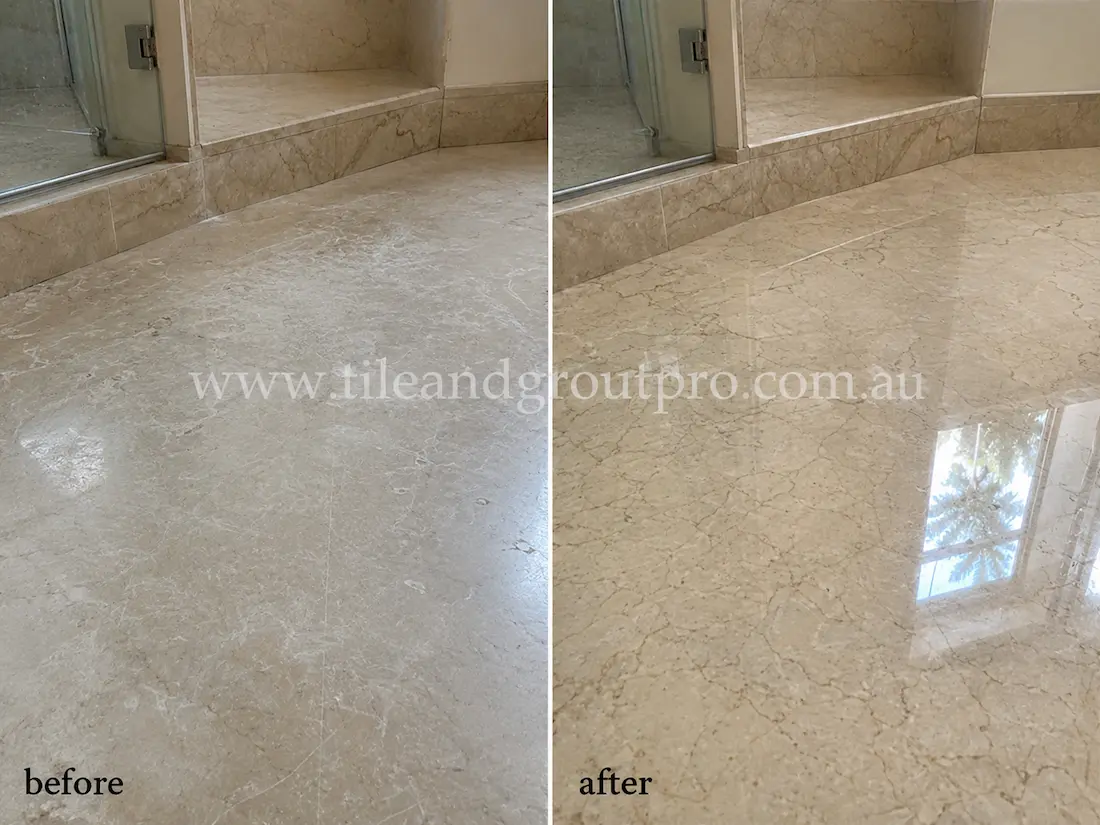 Beige marble bathroom floor near shower enclosure with dull finish, etching, and light surface wear before professional stone polishing.