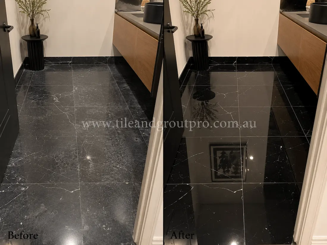 Before tile renewal, the black marble bathroom floor tiles showed haze, water spotting, and reduced shine around the vanity area in a modern bathroom.