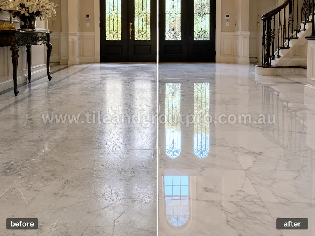 Luxury home entryway with white marble floor tiles before grinding, featuring visible scratches, dull finish, etched stone surface, and reduced shine near the front doors and staircase.