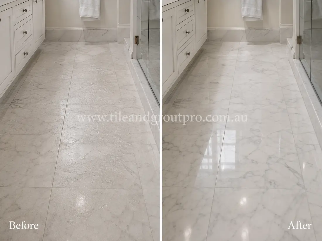 White marble bathroom floor beside a glass shower enclosure, showing etching, dullness, and surface wear before tile resurfacing and polishing.