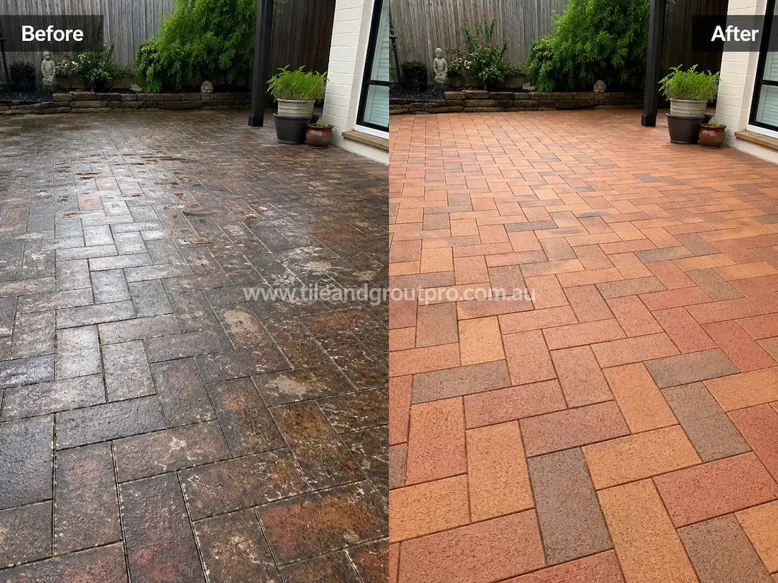 Outdoor patio with herringbone brick pavers before sealer stripping, showing dark sealer build-up, patchy whitening, and worn brick colouring in a landscaped backyard setting.