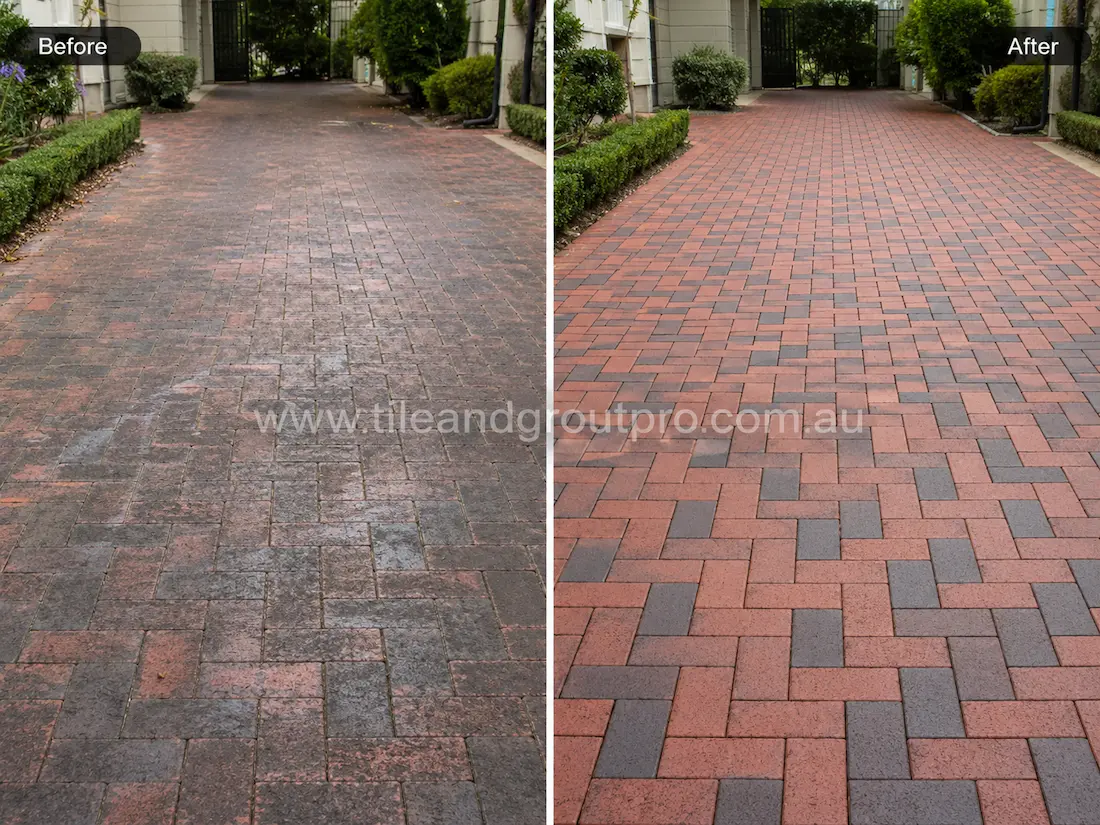 Residential driveway with red and charcoal brick pavers before sealer stripping, featuring worn sealer build-up, dark staining, and patchy faded areas across the paved entrance.