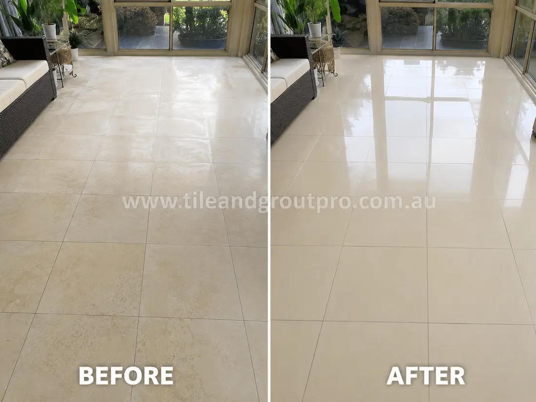 Bright enclosed sunroom with cream porcelain floor tiles before sealer stripping, featuring hazy sealer build-up, cloudy surface marks, and uneven shine near large windows and lounge seating.