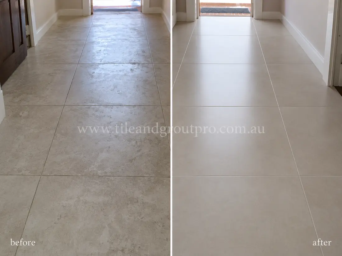 Residential hallway with light grey porcelain floor tiles before sealer stripping, featuring cloudy sealer residue, uneven sheen, and worn dull patches across the tiled walkway.