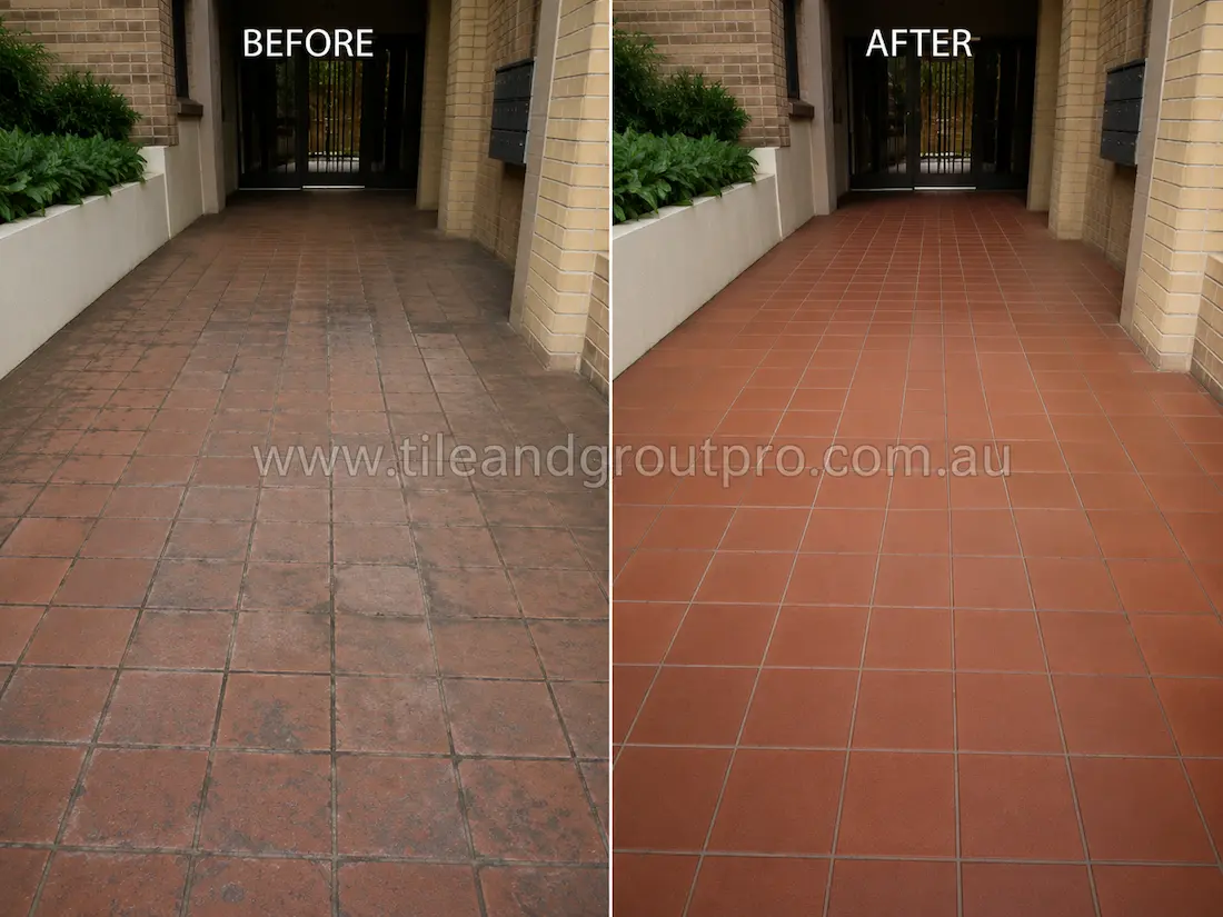 Before tile renewal, red quarry tiles at an apartment building entrance walkway exhibited heavy pedestrian wear, embedded dirt, dull finish, and discoloured grout lines.