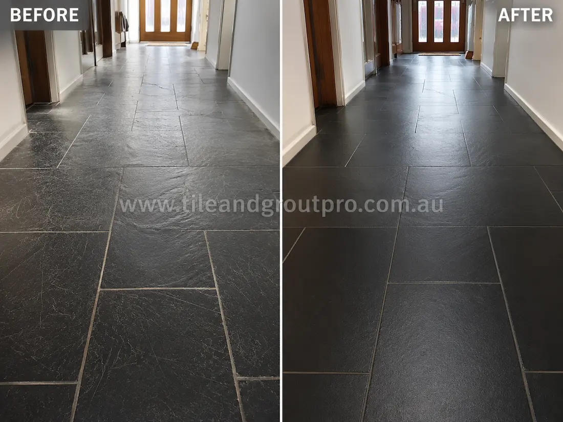 Dark black slate hallway floor tiles with fine scratches and worn texture before scratch removal service in a residential interior corridor.