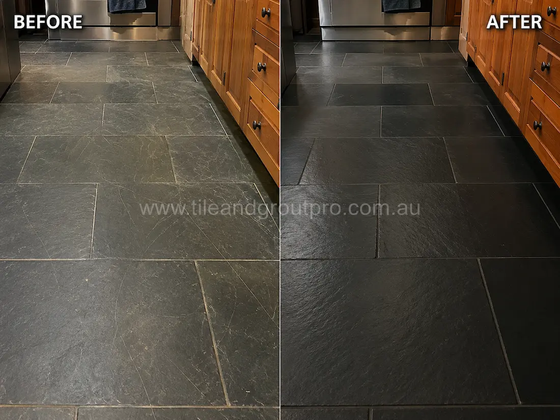 Black slate kitchen floor tiles with visible surface scratches and dull wear before scratch removal treatment in a residential kitchen.
