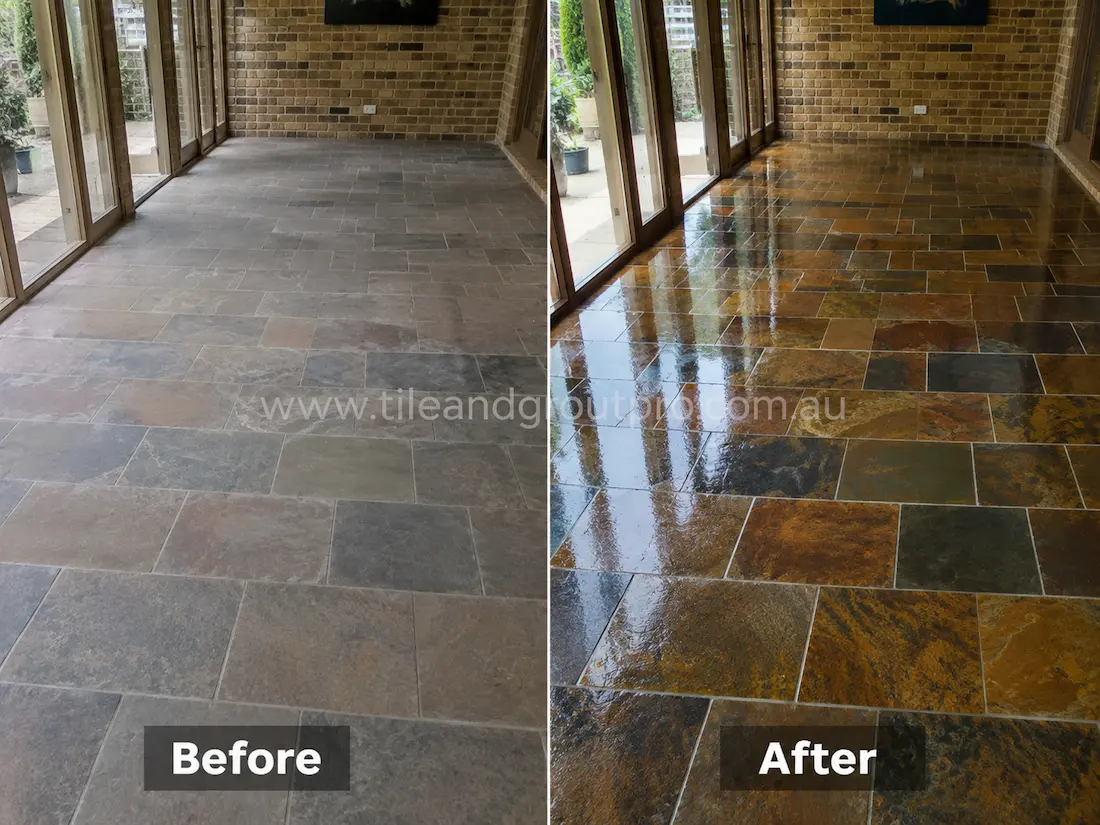 Before stone-polishing of natural slate floor tiles in a sunroom with uneven sheen, faded rust tones, and worn stone texture near large glass doors.