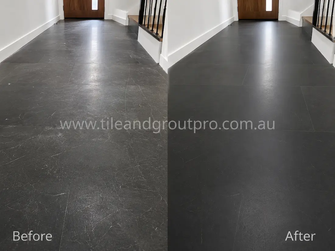 Dark soapstone hallway floor tiles with surface scratches and dull finish before scratch removal in a residential entryway.