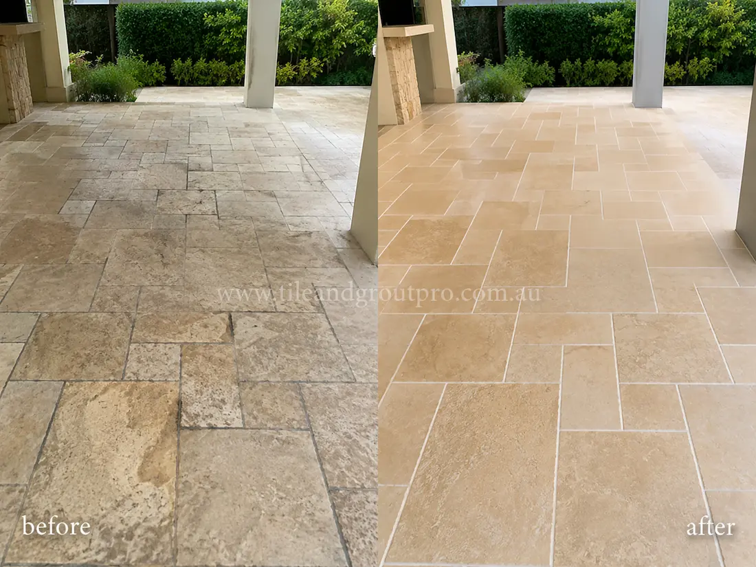 Outdoor patio travertine pavers before grinding, featuring weathered stone surfaces, dark staining, and worn grout joints across the covered entertainment area.