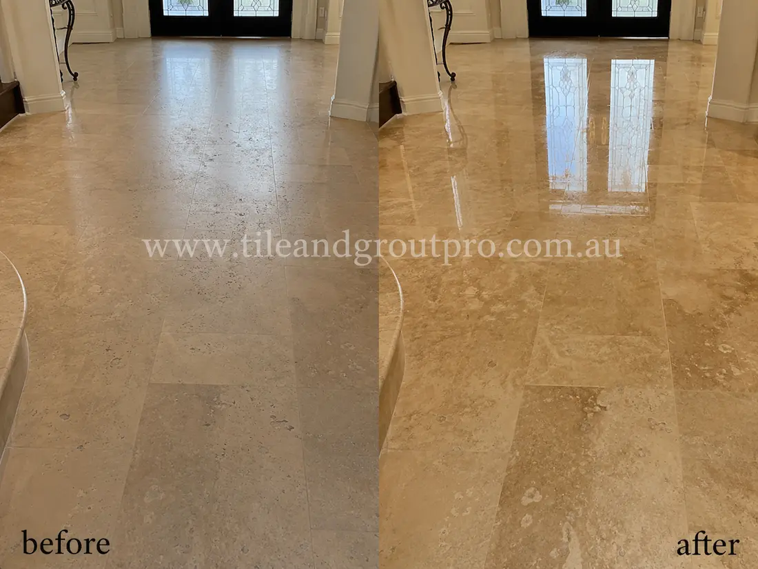 Before stone polishing, the beige travertine entryway floor tiles appeared faded and matte with visible wear in a luxury home foyer with dark double doors.