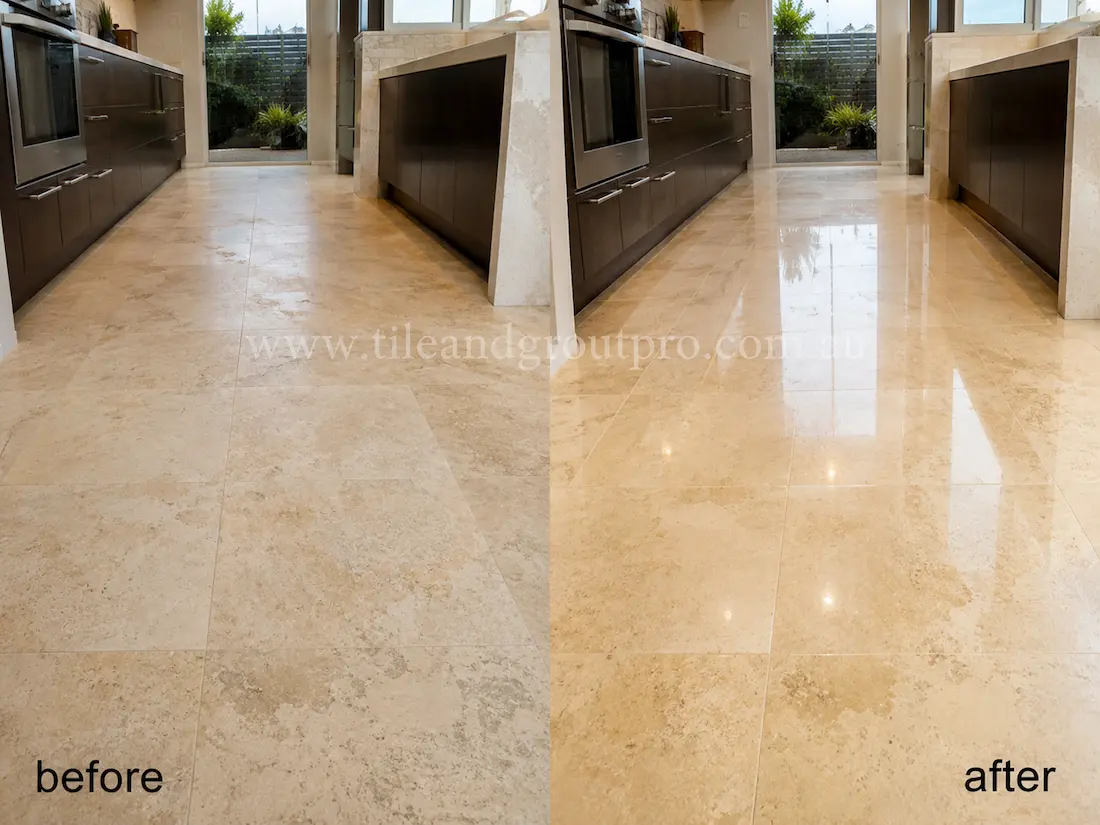 Before stone polishing, the light travertine kitchen floor tiles had a dull finish and patchy surface appearance in a modern kitchen with dark cabinetry and island bench.